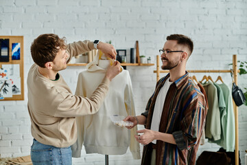 Two men stand next to a mannequin in a designer atelier