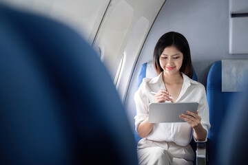 Businesswoman working on tablet during flight. Concept of business travel and digital connectivity