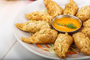 Fried stuffed momo dumplings with sauce