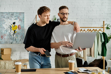 A gay couple stands side by side in front of a laptop, passionately working together on trendy...