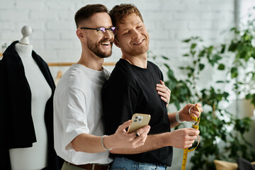 Two men, a gay couple, stand side by side working on trendy attire in their designer workshop.
