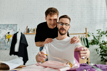 Two designers examine a shirt laid out on a table in their trendy workshop.