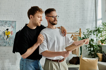 Two men, a gay couple, stand side by side in a designer workshop, passionately creating trendy...