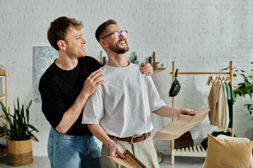 Two men in a clothing workshop examining a cardboard piece.