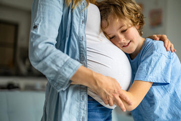 Little boy with his pregnant mother at home
