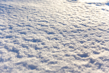 Winterstruktur im Licht: Schneefläche mit glitzernder Textur bei Sonnenschein
