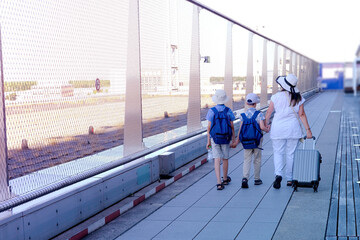 family boarding plane, woman with suitcase, two children, young traveler, boys of 8-10 years old...