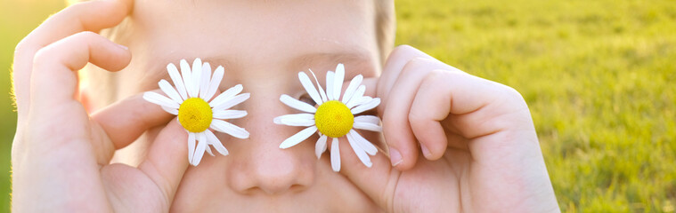 happy happy romantic boy 8 years old holding chamomile flower front of eyes, enjoy life, human...