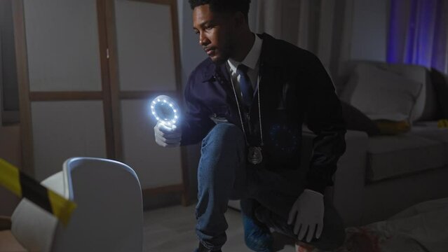 A focused african american man inspects a crime scene with a magnifying glass in a dimly lit room.