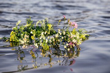 Flower Wreath on Water River. Herbal Wreath Symbol Summer Solstice Day. 