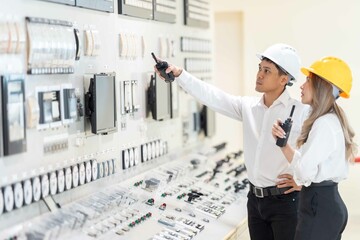 Asian engineers, men and women, employees of power plants deeply Work together smoothly Check the...