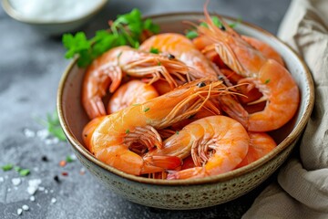 Bowl of succulent cooked prawns, served with parsley on a rustic table