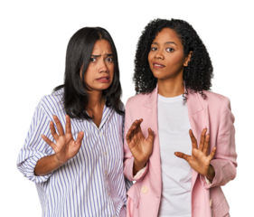 Young Latin businesswomen in studio rejecting someone showing a gesture of disgust.