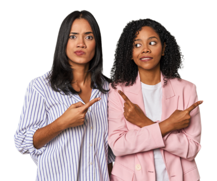 Young Latin businesswomen in studio points sideways, is trying to choose between two options.