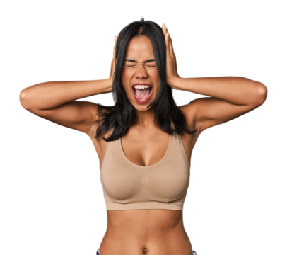 Young Filipino woman in light wear  covering ears with hands trying not to hear too loud sound.