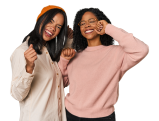 Young Latin friends together in studio celebrating a special day, jumps and raise arms with energy.