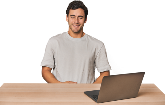 Hispanic young man working on laptop laughs and closes eyes, feels relaxed and happy.