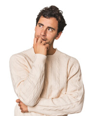 Young Hispanic man in studio relaxed thinking about something looking at a copy space.