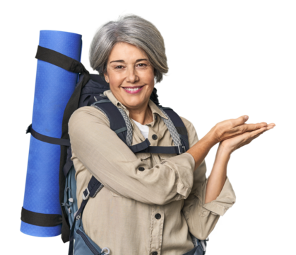 Caucasian mid-age female with hiking gear holding a copy space on a palm.