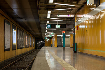 Obraz premium Leerer U-Bahnhof mit gelben Wänden und Bahnsteig 