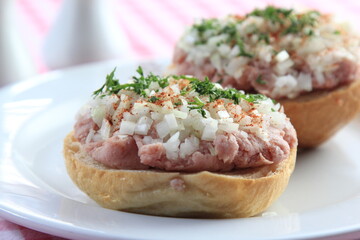 mettbrötchen with onions on wooden table