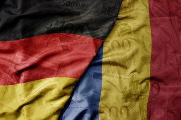 big waving realistic national flag of romania and national flag of germany on a euro money banknotes background. finance concept.