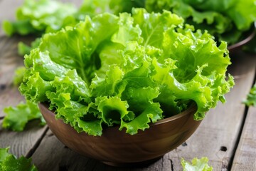 Vibrant green lettuce leaves in a rustic wooden bowl on a wooden background