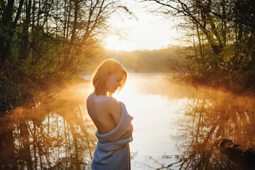 a young woman enjoy sunrise on the water