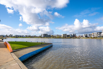 Urban waterfront view of Caroline Springs Lake with some modern and new residential suburban houses in the distance. Melbourne VIC Australia