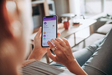 Woman using mobile banking app on smartphone at home