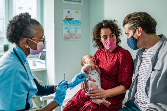 Pediatrician getting ready to vaccinate a newborn baby