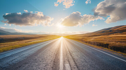 Naklejka premium Open road to sunset. Scenic view of an empty asphalt road leading towards the setting sun, promising a journey filled with possibilities.