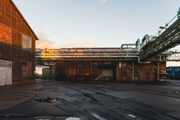 Alte Industriegebäude im Abendlicht mit Rohrleitungssystemen – Zeugnis technischer Vergangenheit