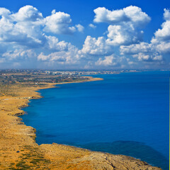 Fototapeta premium sea bay with rocky coast under cloudy sky at the summer day