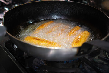 Chvishtari, Georgian cornbreads with cheese inside, are fried in a frying pan in oil. Cook roasts the Chwishtari in a frying pan.
