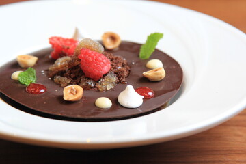 
Chocolate with raspberry, blackberry, mint, in a white plate