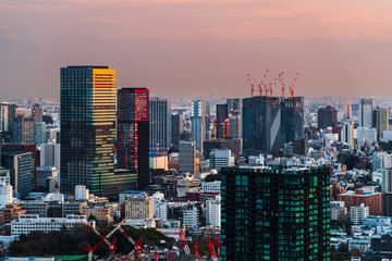 Obraz premium 東京の都市夕景 夕焼け色の超高層ビル群【東京都・港区】 Sunset view of the city of Tokyo. Sunset colored skyscrapers. - Japan