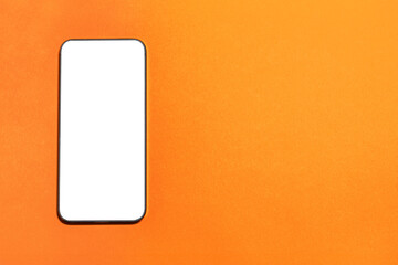 A smartphone with a blank screen on an orange background. Image with copy space.