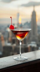 A classic New York Manhattan cocktail with a cherry garnish in a sleek martini glass on a rooftop...