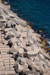 Large concrete protective blocks next to a seawall at a port