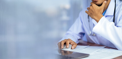 Doctor using laptop or computer with copy space background.