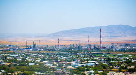 Working oil refinery. Top view of an industrial enterprise near a populated area. Large factory in...