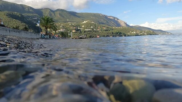 Wave washing up on pebble beach in Greece