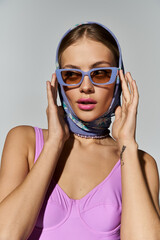 Stylish woman exudes confidence in sunglasses and head scarf.