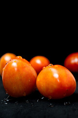 Fresh tomatoes isolated on black background