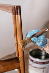 Carpenter applying lacquer to wooden furniture