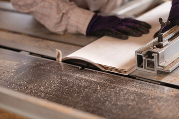Close up image of carpenter hand using circular saw machine in c