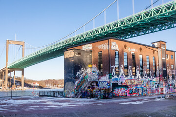 Graffiti on building wall with Alvsborg suspension bridge in city