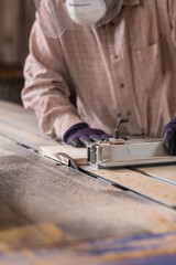 Manual worker using circular saw machine in carpentry workshop