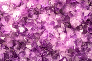 Amethyst purple crystals. Gems. Mineral crystals in the natural environment. Texture of precious and semiprecious stones. Seamless background with copy space colored shiny surface of precious stones.